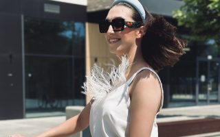 kobieta uśmiechnięta w okularach przeciwsłonecznych jedzie na hulajnodze