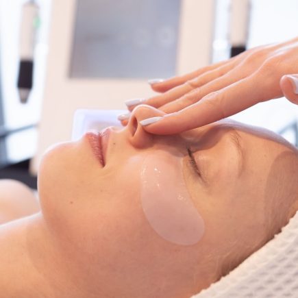 kuracja retinolem instytut piękna masiak twarz kobiety podczas zabiegu w salonie kosmetycznym