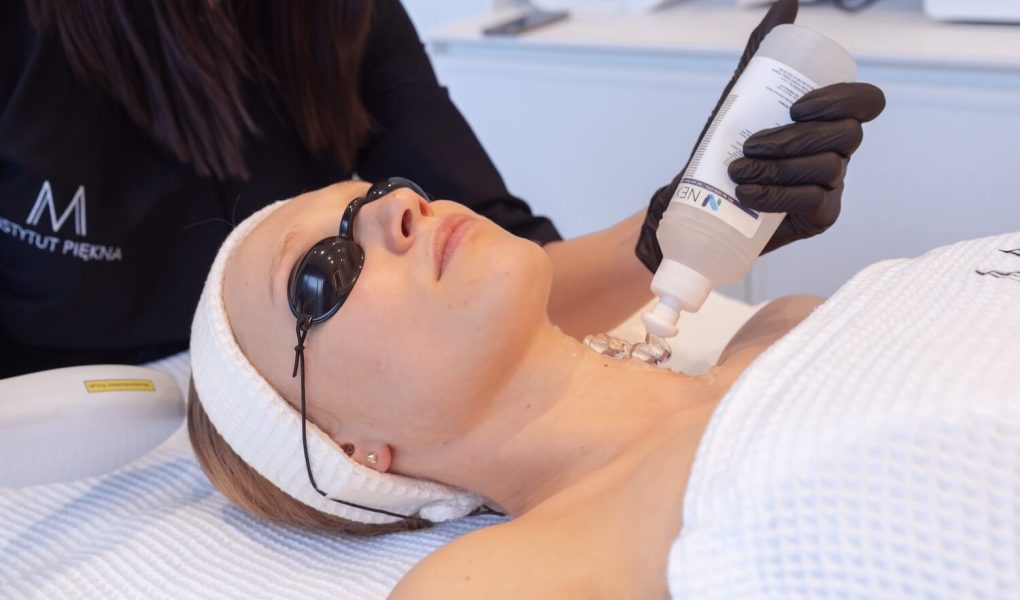kobieta u kosmetyczki w trakcie zabiegu laserowego pielęgnacja szyi i dekoltu