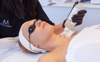 kobieta u kosmetyczki w trakcie zabiegu laserowego pielęgnacja szyi i dekoltu